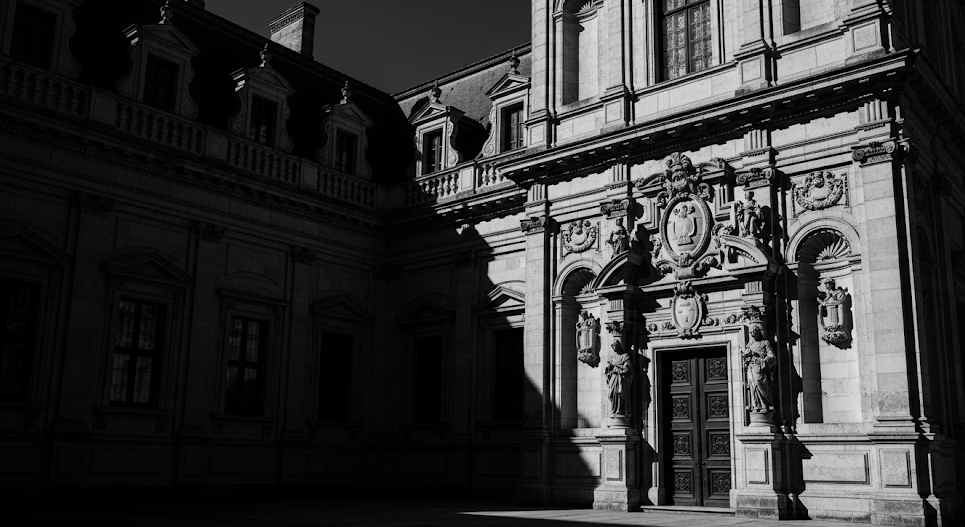 Black and white photograph of an ornate building facade with detailed architecture.
